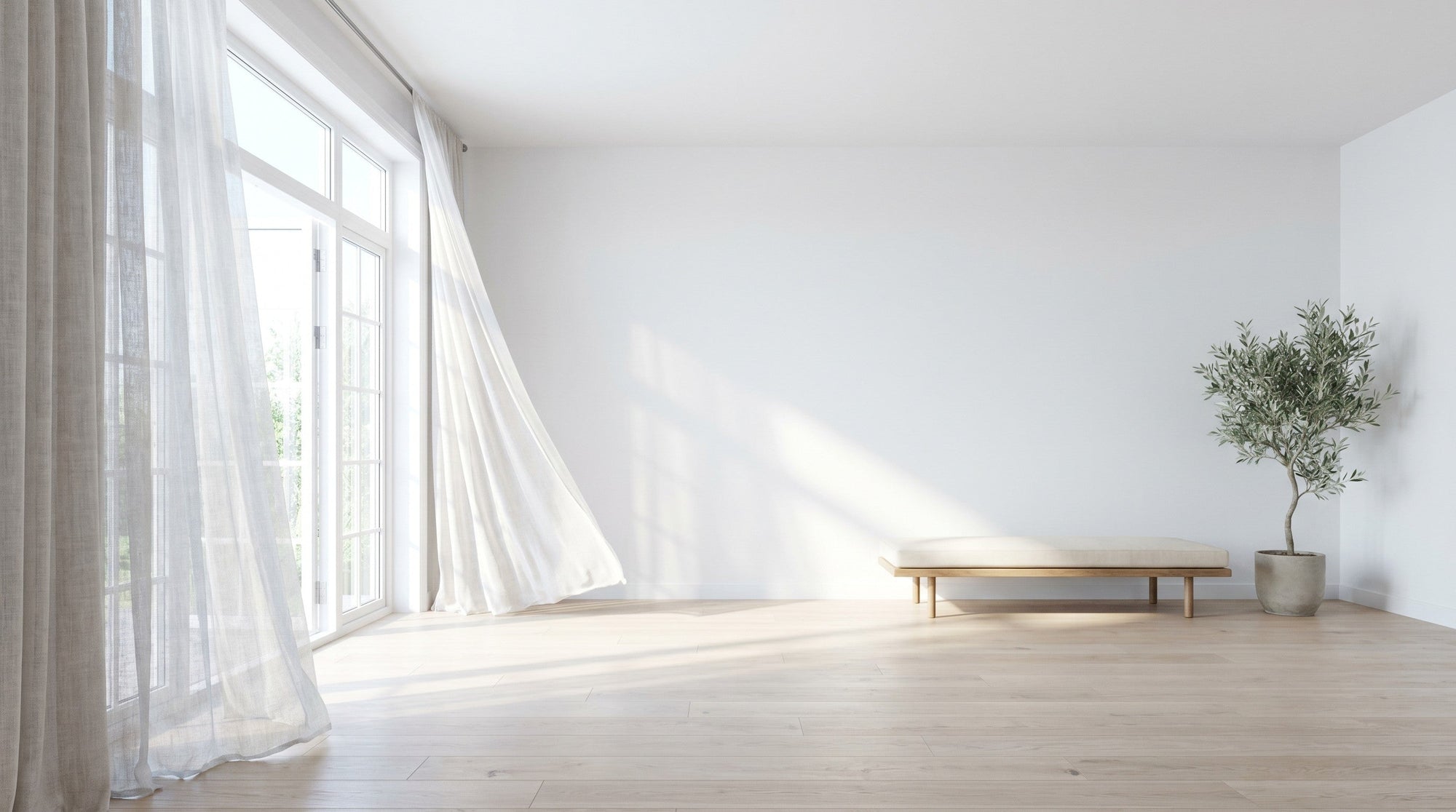 A bright, airy living room with a tall window open to the garden and a sheer linen curtain lifting in the breeze over a pale wood floor.