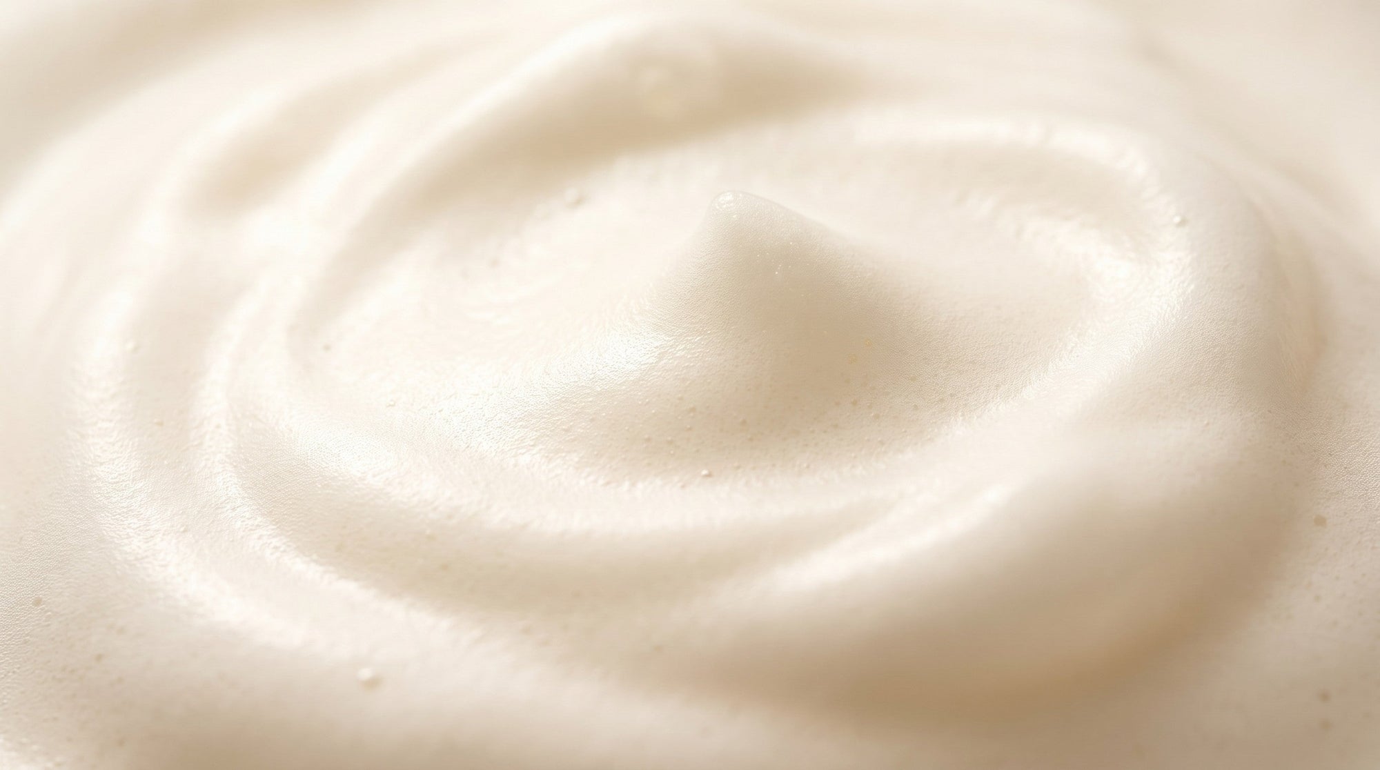 Close macro of soft, creamy white soap lather filling the frame.