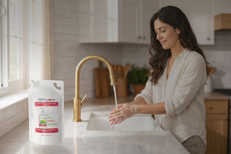 Peppermint & Lemon Liquid Hand Soap 5X Refill while she washes her hands at the kitchen sink
